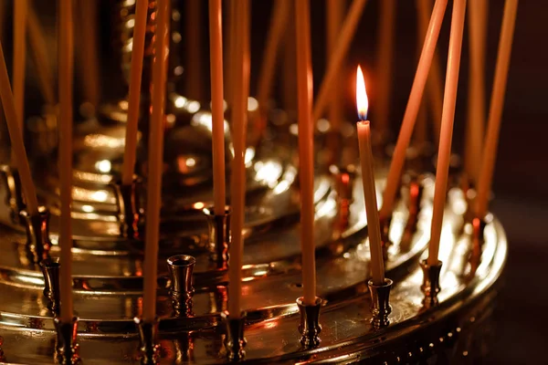 Muchas velas ardiendo por la noche en la iglesia. Grupo de velas encendidas en la oscuridad. Primer plano. espacio de copia . — Foto de Stock