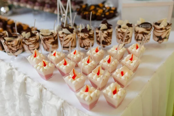 Candy bar en la ceremonia de la boda con un montón de diferentes postres modernos, cupcakes, dulces con frutas. Deliciosa barra de caramelo. Concepto de catering. enfoque selectivo — Foto de Stock