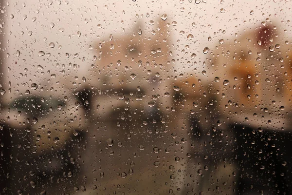 drops of water from the rain flow down the glass. Raindrops on window. Sadness, longing, dullness, autumn depression, gloom. Rainfall, Drip, Raining, Droplets of water