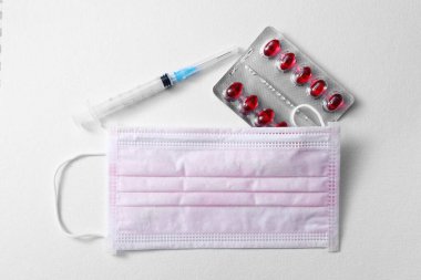 Tıbbi maske, ilaç, şırınga, covid-19 sembolü, koronavirüs, beyaz arka planda tıbbi ilaçlar. Hijyen ve Sağlık Konsepti. Boşluğu kopyala.