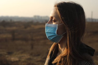 Bulaşıcı hastalıklara karşı koruyucu maske takan bir kadının fotoğrafı, koronavirüs, covid-19 ve açık havada grip. kopyalama alanı. Avrupa 'da Coronavirus salgını. Grip salgını önleme.