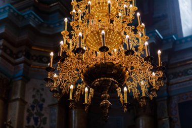 Katedral Hıristiyan kilisesinde büyük bronz avize ve elektrikli mumlar. seçici odak.