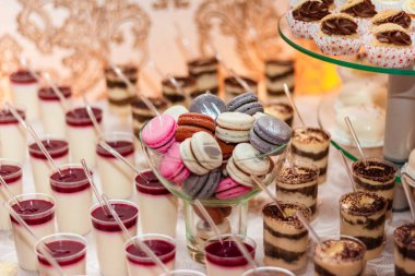 Kremalı tatlılar, bisküviler. Farklı tatlı hamur işleri, küçük renkli tatlı kekler, makaron ve tatlı büfedeki diğer tatlılar. Doğum günü için çikolata, düğün partisi..