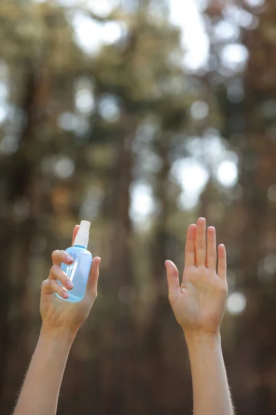 woman hands holding alcohol spray or anti bacteria spray outdoor to prevent spread of germs, bacteria and virus, quarantine time, focus on close up hands. coronavirus. copy space