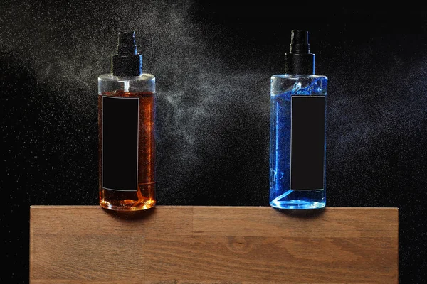 two jars, cans with yellow and blue lotion. two spray spraying cans on black background on wooden stand. copy space on cans, jars. selective focus. barbershop.