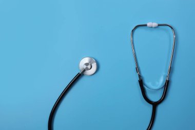 Mavi arka planda asılı steteskop tıbbi ve sağlık konsepti için ideal.
