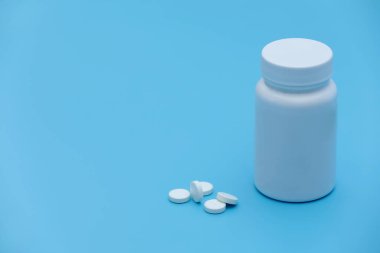 Mavi arka planda bir sürü hap ve tablet var. İzole edilmiş. Uzayı kopyala Mavi arka planda beyaz kapsüller. Soğuk algınlığı tedavisi.