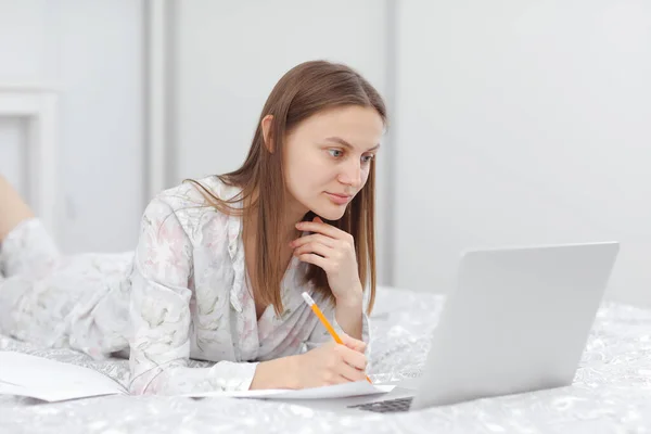 Beautiful Young Woman Working Using Laptop Computer Makes Notes Bedroom — Stock Photo, Image