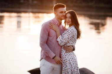 Kumsalda birlikte vakit geçiren mutlu çiftin yakınlaşması. Suyun kenarında birbirine aşık bir çift. Sıcak yaz günü