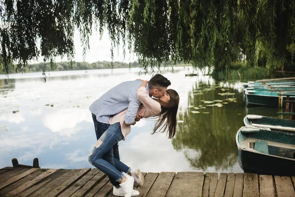 Cute couple walking near water. Girl in a white shirt. Pair by the river. Loving young couple near the river with boats. love without borders. selective focus.