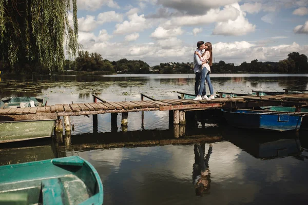 Cute couple walking near water. Girl in a white shirt. Pair by the river. Loving young couple near the river with boats. love without borders. selective focus.