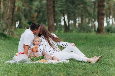 Babacığın parkta, ormanda omzunda bir kız çocuğu taşıyor. Yaz tatili kavramı. Babalar günü, anneler günü, bebekler günü. Birlikte vakit geçirmek. Aile görünüşü. Öpüşen çift