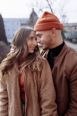 Eski şehir geçmişinde genç ve mutlu bir çift. Eski şehrin avlusunda yürüyüş yapan bir aşk çifti. Arka planda, kırmızı tuğla duvarlar. seçici odak.