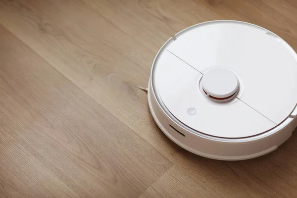 Robot vacuum cleaner performs automatic cleaning of the apartment at a certain time. white robot vacuum cleaner. home cleaning. Smart home. selective focus.