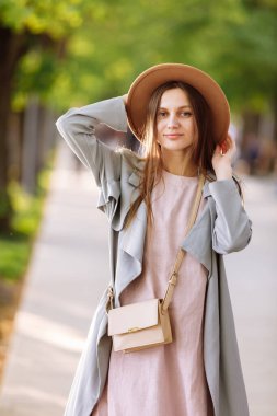 Uzun saçlı, rüzgârda uçan ve yazın parkta kahverengi şapkalı güzel bir esmer kadın. Mavi gözlü güzel bir genç kızın vesikalığı. Yüzeyin derinliği.