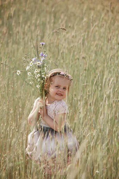 Giovane bambina dai capelli lunghi, vestito bianco solitario passeggiando nel campo di papaveri e raccogliendo fiori per un bouquet — Foto Stock