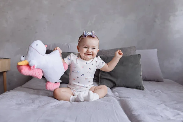 Прекрасна Усміхнена Маленька Дівчинка Обручем Грає Іграшкою Єдинорога Ліжку Вдома — стокове фото