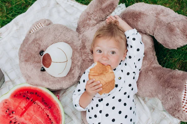 Милая Маленькая Девочка Ест Круассан Лежа Одеяле Пикник Летним Отпуском — стоковое фото