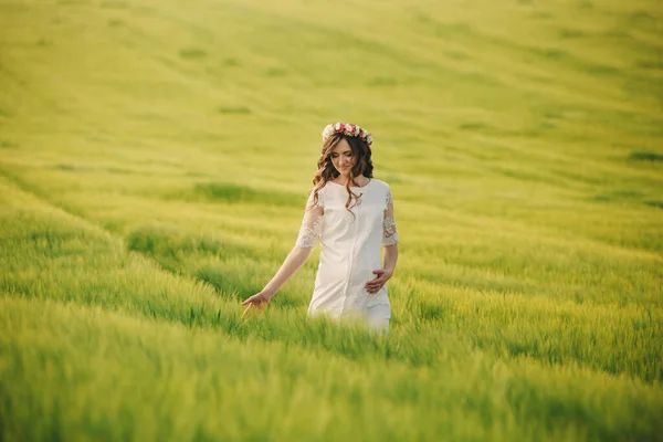 穿着白衣头戴花环的孕妇正在草地上放松 母性概念 选择性重点 — 图库照片