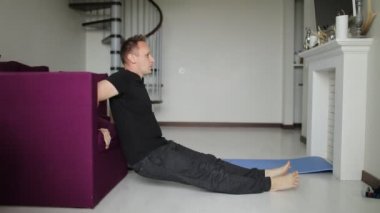 Atletik özgüvenli adam evde egzersiz yapıyor. Genç formda adam evindeki oturma odasında şınav çekiyor. Spor ve sağlıklı yaşam tarzı.