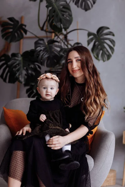 Bela Mãe Senta Uma Cadeira Mantém Sua Filha Colo Casa — Fotografia de Stock