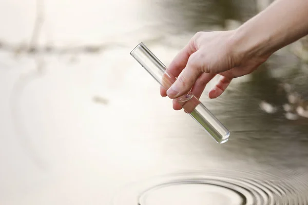 Un scientifique et un biologiste hydro-biologiste prélèvent des échantillons d'eau pour les analyser à l'extérieur. Hand est recueille de l'eau dans un tube à essai. Concept de pollution de l'eau des étangs . — Photo