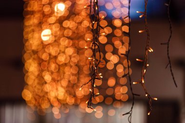 Akşam kentinde bir kafede ışıklar ve parlak bir bokeh. Neşeli lirik ruh hali. seçici odak.