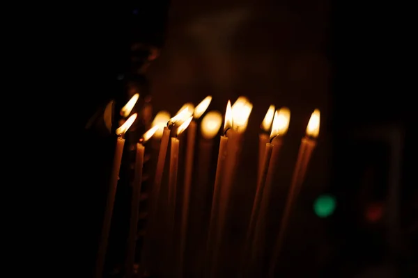 Närbild Brinnande Ljus Kyrkan Mörk Bakgrund Ett Varmt Gult Ljus — Stockfoto