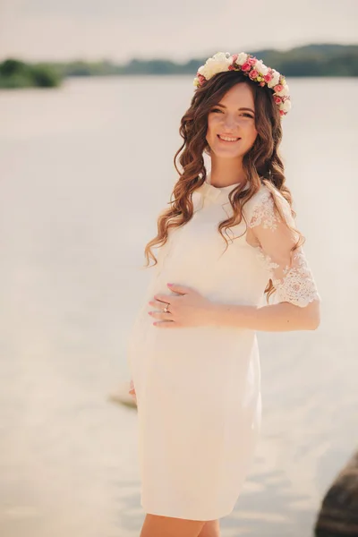 Hermosa Mujer Embarazada Joven Está Usando Vestido Blanco Corona Floral —  Fotos de Stock