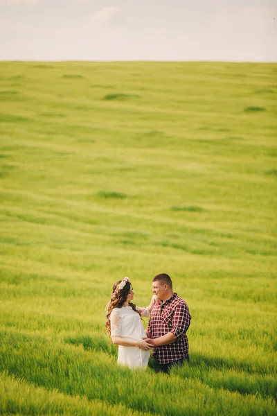 等待宝贝 为人父母 怀孕的年轻女子和她的丈夫高兴地牵着手 走在户外绿草的背景下 选择性重点 — 图库照片