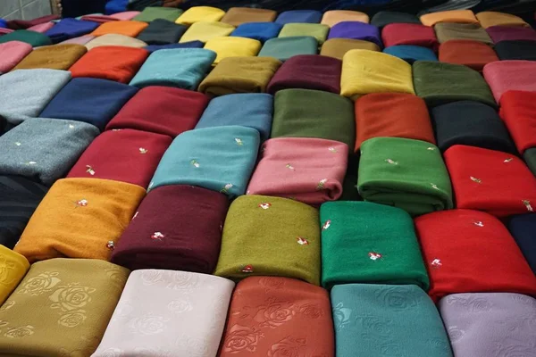 Colorful woven silk cloth fabric bolts for sale in a market in Hanoi Vietnam