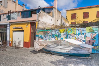 Funchal, Portekiz - 10 Kasım 2019: Sokaktaki balıkçı teknesi ve duvar boyası Rua Portao de Sao Tiago 