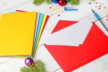 Boş kağıtlı kırmızı zarf, Noel kutlaması ya da davetiye konsepti, Noel ağacı dalları, Noel baloları, konfeti.