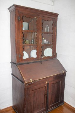 Tabakları ve katlanan bir masası olan antik gardırop, 19. yüzyılın başlarında ahşaptan yapılmıştır..