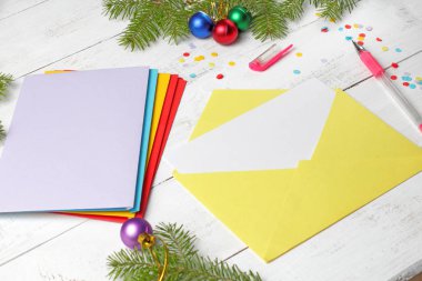İçinde boş kağıt olan sarı zarf, Noel kutlaması ya da davetiye konsepti, Noel ağacı dalları, Noel baloları, konfeti..