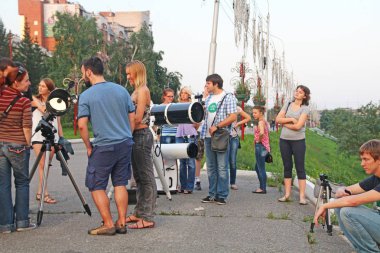 Krasnoyarsk, Rusya, 08 / 05 / 2014 İllüstrasyon Editörü Gençler bir şehir parkında teleskop eğitimi alıyor, yaz eğlencesi.