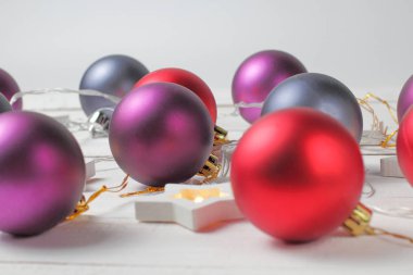 Noel süsleri, beyaz arka planda çelenk olan toplar..