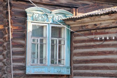 Eski bir ahşap evin çirkin çift oymalı pencereleri, yakın plan..