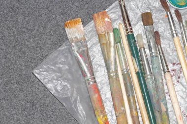 Sanatçılar farklı boyutlarda ve şekillerde fırçalar masanın üzerinde, metin için yer.