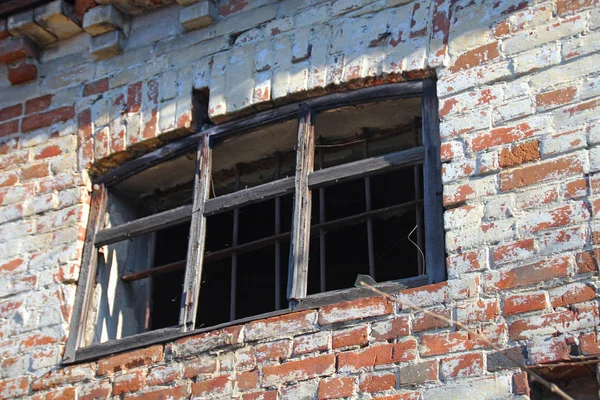 Ventana rota en la pared de un antiguo edificio abandonado de ladrillo, concepto de la pérdida de monumentos arquitectónicos . — Foto de Stock