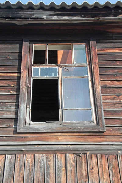 Wybite okno w starym opuszczonym budynku z drewna, stłuczone szkło. — Zdjęcie stockowe