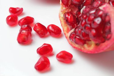 Beyaz zemin üzerinde nar taneleri yakın plan, parlak doğal renk.