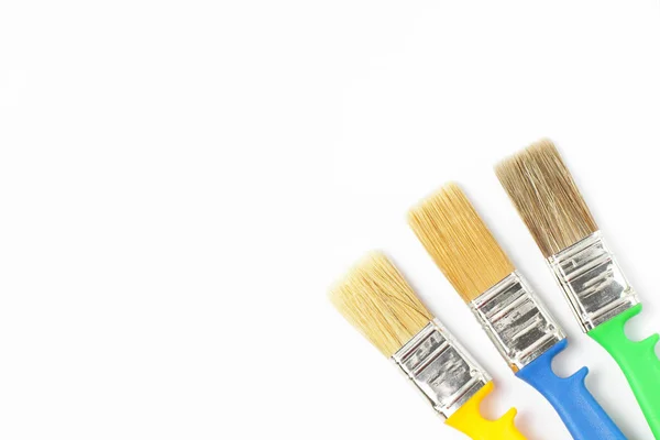 Paint brushes of different colors on a white background close-up, flat lay, place for text. — 스톡 사진