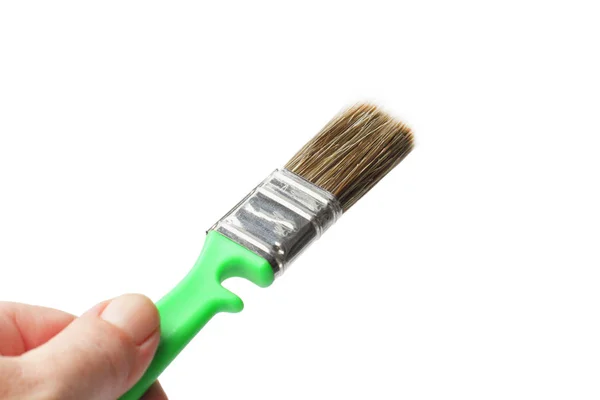 Paint brush in the hand of a worker on a white background, isolate, close-up, place for text. — 스톡 사진