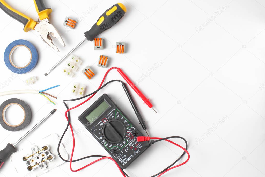 Electrician tools and instruments on a white background, flat lay, close-up, place for text.