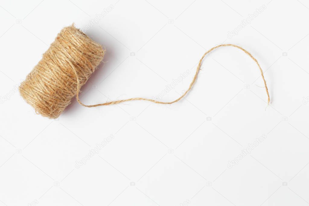 Skein of jute coarse threads on a white background close-up, place for text.