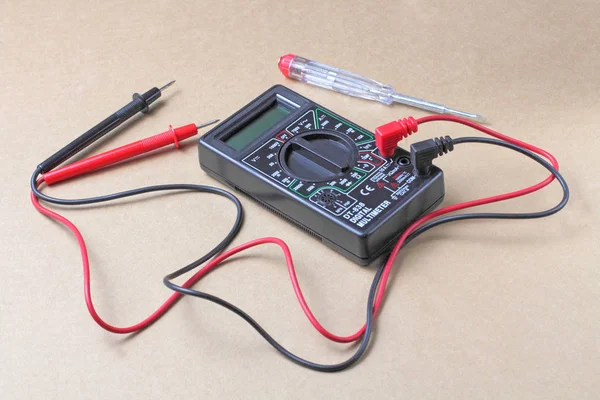 Les principaux appareils d'un électricien sur fond d'artisanat, un testeur et un multimètre numérique . — Photo