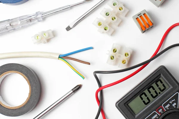 Flat lay, aparelhos e ferramentas eletricistas em um fundo branco rústico, close-up . — Fotografia de Stock