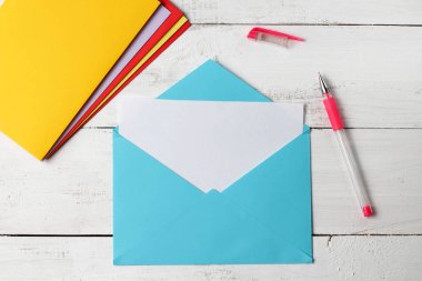 Beyaz arka planda karşılama kavramı olan boş beyaz bir kağıt ile zarf.