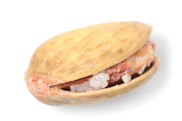 Фисташковый орех с зерном соли крупным планом на белом фоне . — стоковое фото